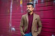 © Eber Braun - Young handsome Indian businessman wearing a brown jacket and blue jeans posing in an urban context