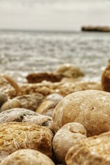 Sticker - A vertical shot of rocks on the beach shore