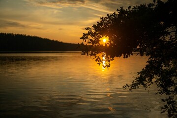 Sticker - Solitary vessel is silhouetted against the backdrop of the sun setting over the horizon