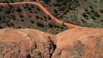 Poster - View from a high rocky cliff on vegetation bushes on a desert and a car