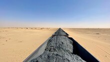 Cargo Train Pictured In A Desert Landscape. Mauritania.