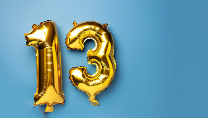 Wall Mural - Banner with number 13 golden balloon with copy space. Thirteen years anniversary celebration concept on a blue background.