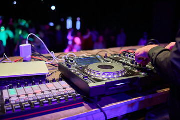 Wall Mural - control DJ for mixing music with blurred people dancing at party in nightclub.