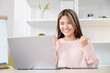 © mangpor2004 - Happy young successful asian woman smiling while looking at laptop computer at home office, work at home, online learning