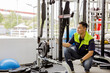 © ฺฺฺBoonterm - Professional Asian male service worker or fitter checks equipment, maintains and secures fitness equipment in indoor gym, provides safety for users : Skilled technicians repair exercise machines.