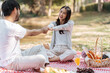 © Charlie's - Happy romantic couple in Valentine Day asian couple hold hands for close moment together. happy couple relaxing together with picnic Basket.