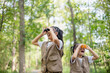 © FAMILY STOCK - Happy Little Asian girls looking ahead and smiling child with the binoculars in the park. Travel and adventure concept. Freedom, vacation