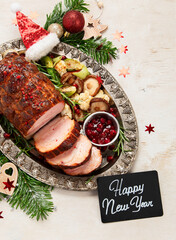 Wall Mural - Roasted sliced Christmas ham on plate with vegetables, festive decoration.