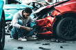 © Anoo - Young black man driver in car accident and holding his head near broken car on the road after a car accident. Car accident on the street, damaged cars after collision. Violation of traffic rules.
