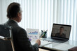 © DragonImages - Mature entrepreneur taking to coworker from another office in online meeting