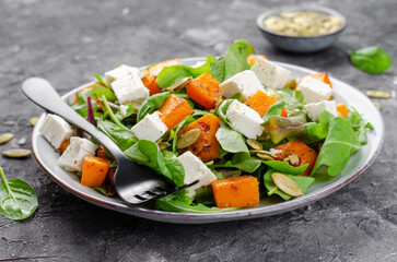 Wall Mural - Pumpkin Salad with Arugula, Feta Cheese, and Pumpkin Seeds, Salad Mix with Roasted Pumpkin, Autumn Salad