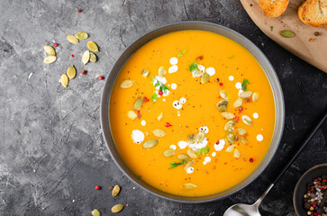 Wall Mural - Pumpkin Soup, Tasty Homemade Pumpkin, Sweet Potato, Carrot Soup in a Bowl on Dark Background