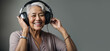 © Tatiana Sidorova - Smiling elderly lady wearing headphones enjoys listening to music