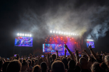 Wall Mural - Detail of people raising hands in front of a music stage.