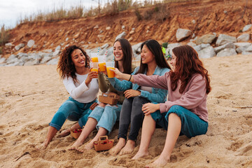 Friends sitting by the beach and having a drink