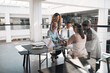 © Flamingo Images - Diverse businesspeople smiling during a meeting in an office lounge