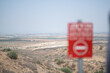 View of the Gaza Strip from Israel. In the foreground, a red warning sign orders people not to proceed further.