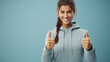 Happy young woman isolated over light blue background showing thumbs up gesture. Generative AI