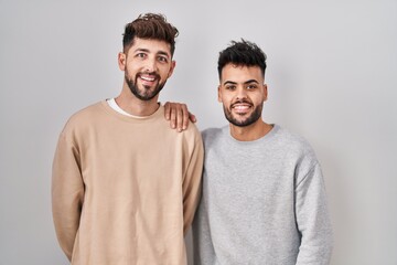 Wall Mural - Young homosexual couple standing over white background with a happy and cool smile on face. lucky person.