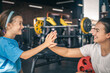 © puhimec - Strong mother and daughter giving high five at gym.