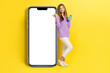 © deagreez - Full length photo of charming lady finger point big device menu screen display offer use modern gadget isolated on yellow color background