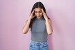© Krakenimages.com - Young teenager girl wearing casual striped t shirt with hand on head for pain in head because stress. suffering migraine.