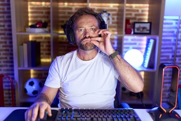 Sticker - Middle age man with beard playing video games wearing headphones mouth and lips shut as zip with fingers. secret and silent, taboo talking