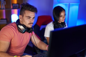 Wall Mural - Man and woman streamers playing video game using computer at gaming room