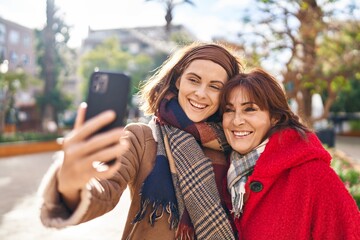 Sticker - Two women mother and daughter make selfie by smartphone at park