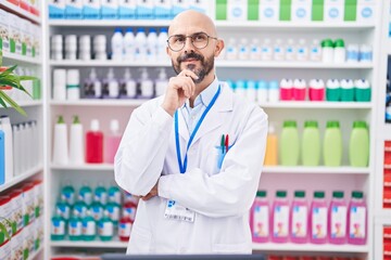 Sticker - Hispanic man with tattoos working at pharmacy drugstore smiling looking confident at the camera with crossed arms and hand on chin. thinking positive.