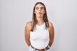 © Krakenimages.com - Hispanic young woman standing over white background making fish face with lips, crazy and comical gesture. funny expression.