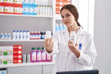 Poster - Young woman pharmacist holding pills bottle at pharmacy