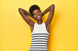 © Asier - Vibrant African woman, white tank-top, yellow studio, stretching arms, relaxed position.