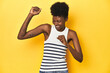 © Asier - Vibrant African woman, white tank-top, yellow studio, dancing and having fun.