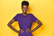 © Asier - African woman in violet tee, yellow studio scene, confident keeping hands on hips.