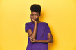 © Asier - African woman in violet tee, yellow studio scene, who is bored, fatigued and need a relax day.