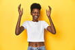 © Asier - African woman, white tee, short hair, yellow studio, joyful laughing a lot. Happiness concept.