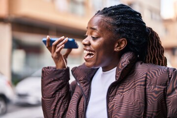 Wall Mural - African american woman smiling confident listening audio message by the smartphone at street