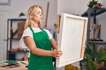 Poster - Young caucasian woman looking at canvas looking at the camera blowing a kiss being lovely and sexy. love expression.