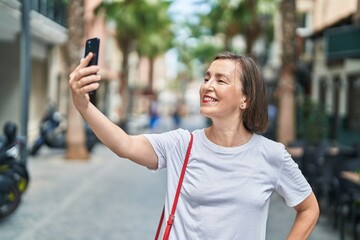 Sticker - Middle age woman smiling confident making selfie by the smartphone at street