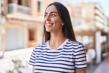 Wall Mural - Young hispanic woman smiling confident standing at street