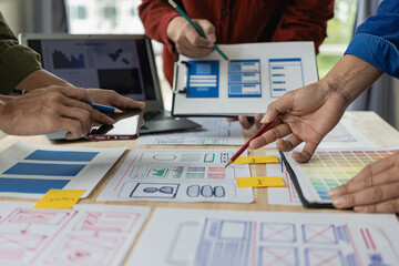Wall Mural - a team of web designers are working together to develop a mobile responsive website with ui/ux front