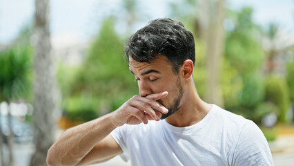 Wall Mural - Young hispanic man sneezing at park