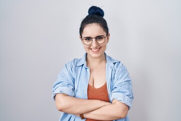 Wall Mural - Young modern girl with blue hair standing over white background happy face smiling with crossed arms looking at the camera. positive person.