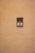 © Cristina - Yellow Roman wall texture background, Italy. Old window on the shabby yellow wall facade. Little cute window on ochre colored stone wall. Old european house background.