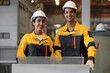 © Nassorn - Hispanic industrial engineers in safety helmet and uniform jacket working in heavy machine engineering factory. Latin technician workers standing control production in metalwork manufacturing facility