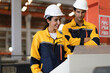 © Nassorn - Hispanic industrial engineers in safety helmet and uniform jacket working in heavy machine engineering factory. Latin technician workers standing control production in metalwork manufacturing facility