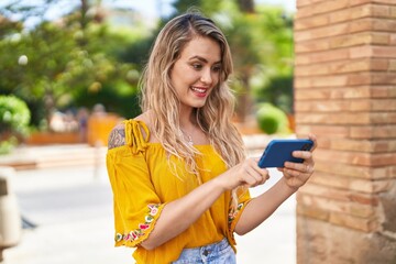 Poster - Young woman smiling confident watching video on smartphone at street