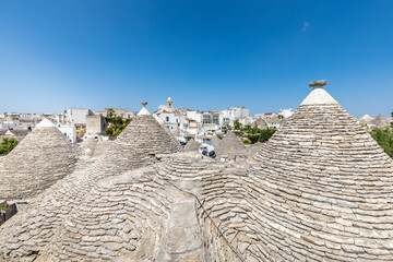 Wall Mural - Alberobello, Italy - July 21, 2021: The Trulli of Alberobello in Apulia in Italy. These typical houses with dry stone walls and conical roofs are unique to the world