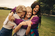 © Jacob Lund - Happy friends hugging in park, enjoying playful day together